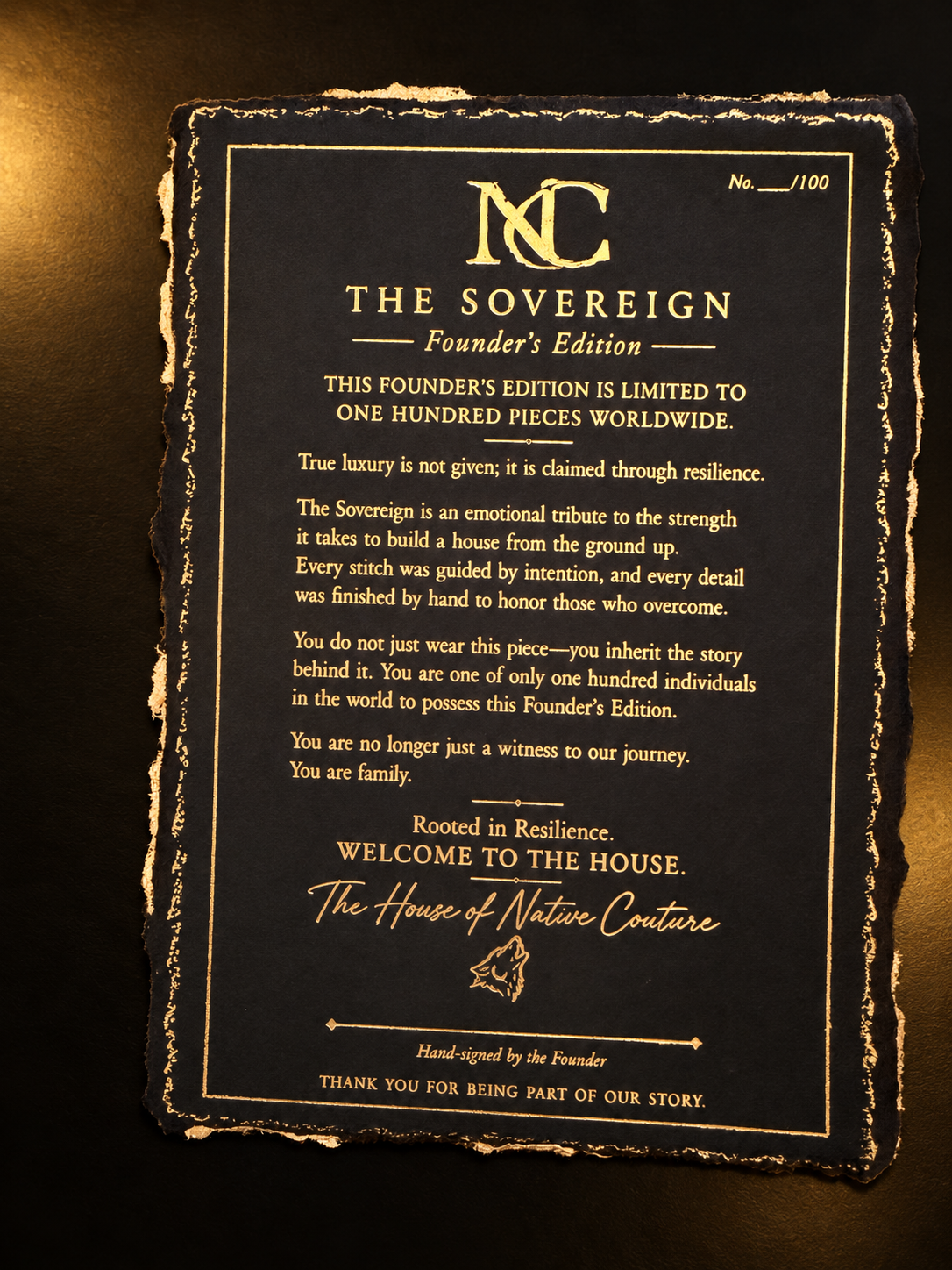 Sovereign Founder’s Edition letter on black deckled paper with gold lettering, photographed against a dark background with warm gold lighting
